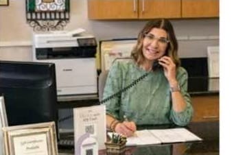 Office manager Kim Castle scheduling an appointment at the front desk